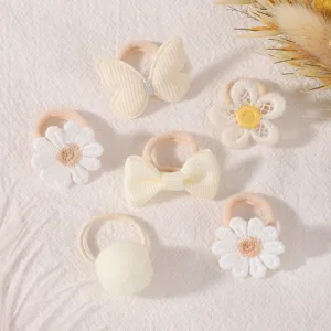 Close-up detail of cute baby hair ties set featuring embroidered daisy and bow design styles.