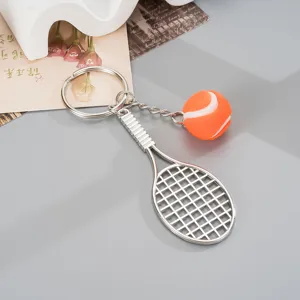 Metal tennis racket keychain with mini tennis ball pendant, stylish bag charm accessory.