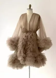 Vue détaillée de la robe en tulle avec des volants duveteux et un nœud élégant à la taille.