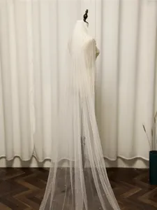 Detailed view of a long ivory bridal pearl tulle wedding veil with delicate pearl accents.