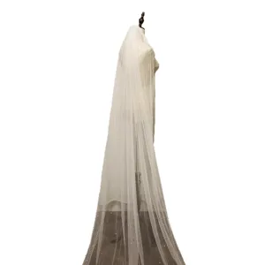 Details of ivory long bridal veil featuring delicate pearls on soft mesh fabric design.