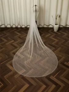 Detailed view of long bridal pearl mesh veil showing ivory tulle fabric texture.