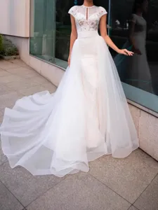 Detailed view of the elegant white bridal wedding dress featuring delicate lace bodice and tulle.