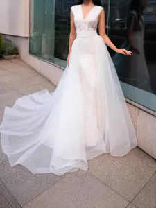 Elegant bridal organza wedding dress with detachable tulle train and V-neck design.