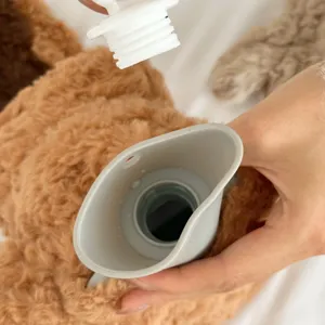 Close-up detail of the fuzzy hot water bottle opening and threaded cap for secure use.