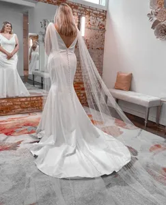 Elegant white wedding dress with long veil, mermaid style bridal gown for photography events.