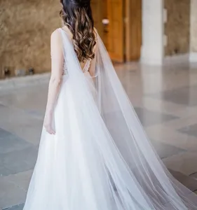 Elegant white bridal wedding cape long sheer veil accessory for photography and bridal gown.