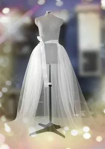 Vue detaillee de la surjupe de mariage en tulle blanc sur mannequin, robe de fete elegante.