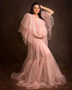 Elegante abito premaman in tulle rosa con maniche a palloncino per servizi fotografici.