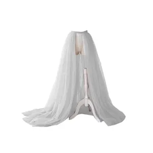 Details of the white bridal detachable tulle overskirt showing fine fabric and elegant train.