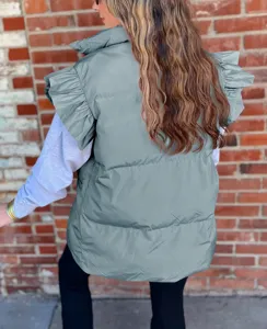 Close-up detail of the stylish grey sleeveless puffer vest featuring elegant ruffle shoulders.