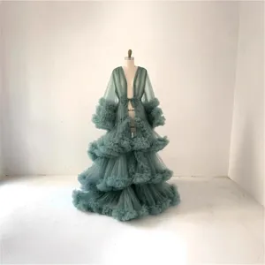 Elegant long sage green tulle maternity dress with tiered ruffles and sleeves for photography.