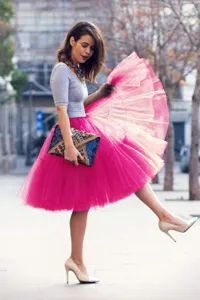Vue détaillée d'un jupon en tulle rose vif présenté dans une rue extérieure.