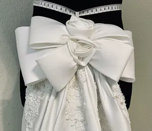 Detachable white satin wedding dress bow train with exquisite lace and pearls for brides.