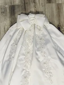 White satin bridal detachable skirt with big bow and floral lace detail for wedding photography.
