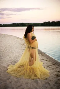Stunning yellow tulle maternity dress with long train and ruffles for beach photography.