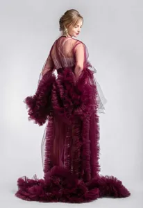 Details of the sheer mesh maternity ruffle dress with dramatic sleeves and long train.