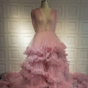 Exquisite details of the pink tulle ruffles, deep V-neckline, and dramatic long train.