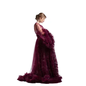 Elegant deep red tulle maternity dress with long sleeves and train for photo studio sessions.