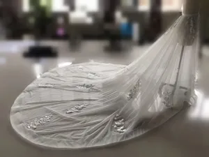 Exquisita falda de novia de tul con aplique y larga cola desmontable en detalle.