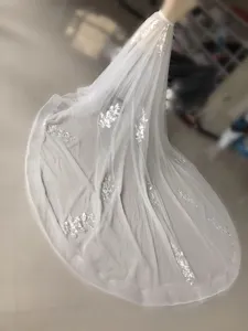 Vista detallada de la falda de novia blanca de tul con hermosa aplicación floral y cola.