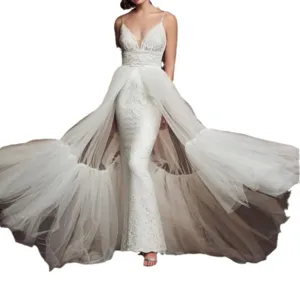 Detail view of a stunning white lace mermaid wedding dress with detachable tulle overskirt train.