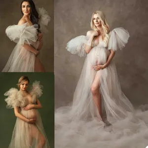 Sheer tulle maternity dress featuring dramatic puff sleeves and elegant off-shoulder design.