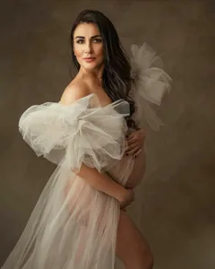 Elegant white maternity tulle dress gown with dramatic puff sleeves for photo shoot session.