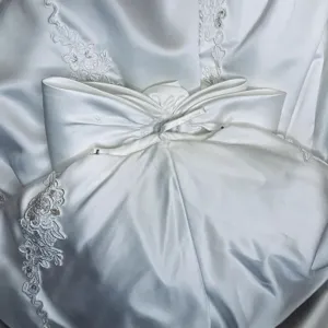 Stunning white satin wedding dress main skirt showcasing elegant lace embroidery and bow detail.