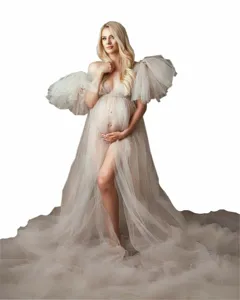 Elegant maternity tulle dress with dramatic puff sleeves and long train for photography.