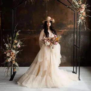 Stunning long tulle dress detail featuring deep V-neck, trumpet sleeves, and flowing skirt.