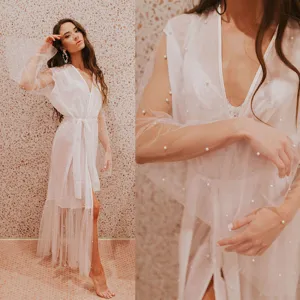 Detailed close-up of white sheer mesh long cardigan dress featuring delicate pearl embellishments.