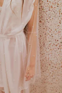 Close-up detail view of the sheer mesh long cardigan with pearl embellishments and waist tie.