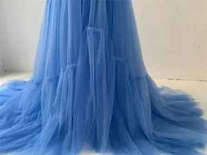 Blue tulle wedding dress detail, long train bridal gown, sheer mesh layered skirt design.
