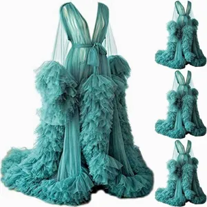 Detailed view of luxurious teal tulle maternity gown with dramatic ruffled sleeves and long train.