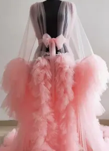 Nahtaufnahme des rosa Tüllmantels mit zarten Rüschen, transparentem Mesh und langer Schleppe.