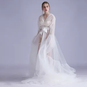 Vista dettagliata del lungo abito in tulle bianco con cintura in satin per foto sposa.