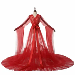 Red sheer tulle fabric, dramatic long floor-sweeping train, elegant satin tie waist sash.
