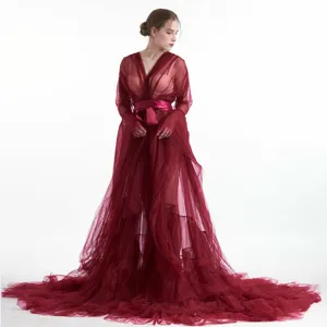 Vista dettagliata dell'elegante vestaglia lunga in tulle rosso vino con cintura in raso.