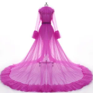 Detailed view of the vibrant magenta tulle sheer robe with dramatic ruffled long train.
