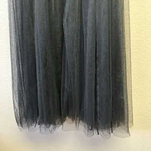 Close-up detail of black layered tulle mesh fabric, showing fluffy skirt hem texture and style.