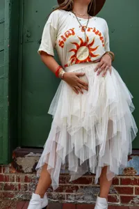 Detail view of the elegant layered irregular tulle midi skirt in creamy white shade.