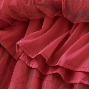 Detail of red mesh cake skirt, layered tulle texture and fine stitching for women's vintage dress.