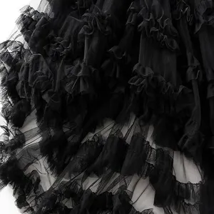 Close-up detail of black layered tulle ruffles, showing the delicate mesh fabric texture.