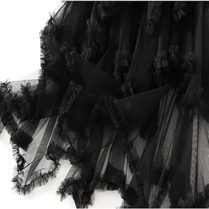 Zwarte tulle rok detail close-up met gelaagde mesh volants en onregelmatige zoom.