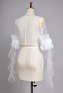 Detailed view of white sheer bridal tulle top with button back and floral sleeves.