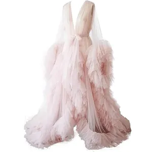 Detailed view of the elegant pink tulle trailing cape, featuring dramatic ruffled sleeves.