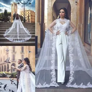 Élégante combinaison de mariée blanche en dentelle avec longue traîne, cape de mariage raffinée.