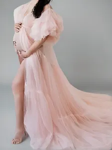 Pink tulle maternity dress detail, fluffy long train gown for pregnancy photo studio.