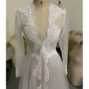 Detail de longue nuisette en dentelle blanche transparente, col V seduisant et finitions florales.
